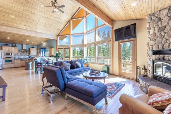 a living room with furniture a large window and wooden floor