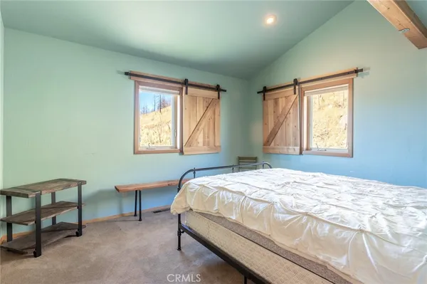 a bedroom with a bed a table and chair
