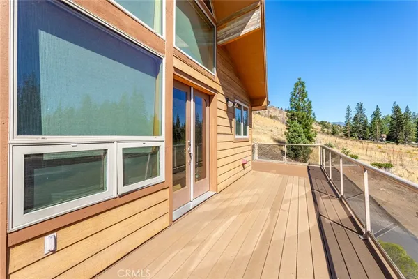 a view of a balcony with wooden floor and fence