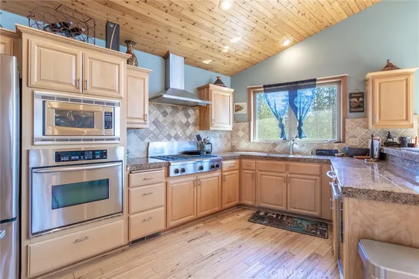 a kitchen with granite countertop cabinets stainless steel appliances and a large window