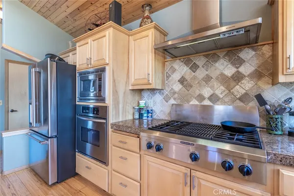 a kitchen with stainless steel appliances granite countertop a stove and a refrigerator