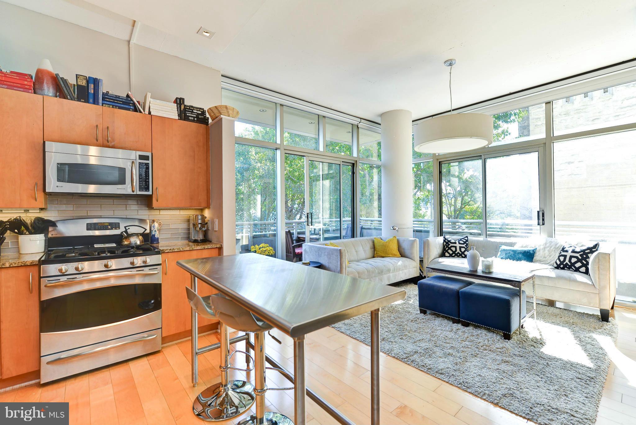 811 4th Street Northwest, Unit 218 Washington, DC 20001 - Photo 2 of 28 a living room with stainless steel appliances granite countertop a couch a dining table and chairs with the floor