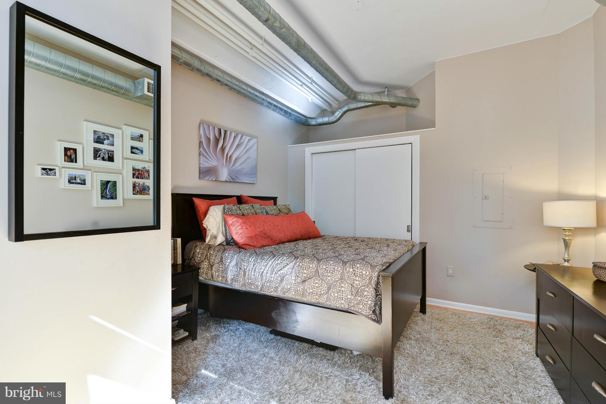 811 4th Street Northwest, Unit 218 Washington, DC 20001 - Photo 14 of 28 a bedroom with a bed and a painting on the wall