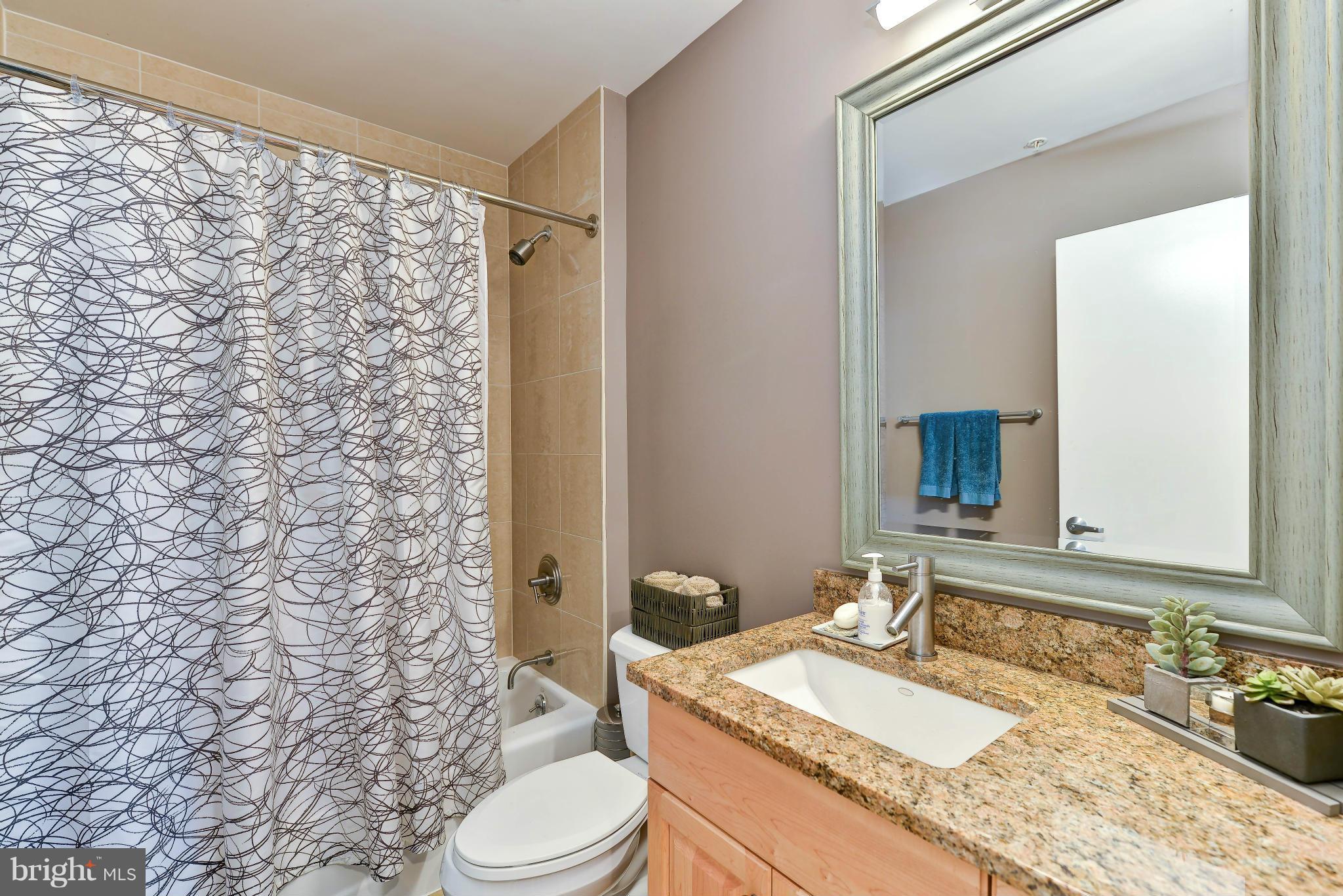 811 4th Street Northwest, Unit 218 Washington, DC 20001 - Photo 17 of 28 a bathroom with a granite countertop sink toilet and shower