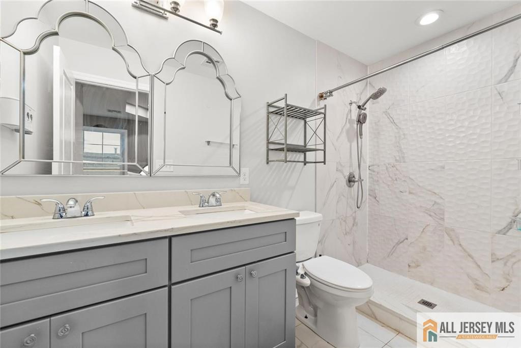 227 Temple Way Colonia, NJ 07067 - Photo 19 of 30 a bathroom with a granite countertop sink mirror vanity and toilet