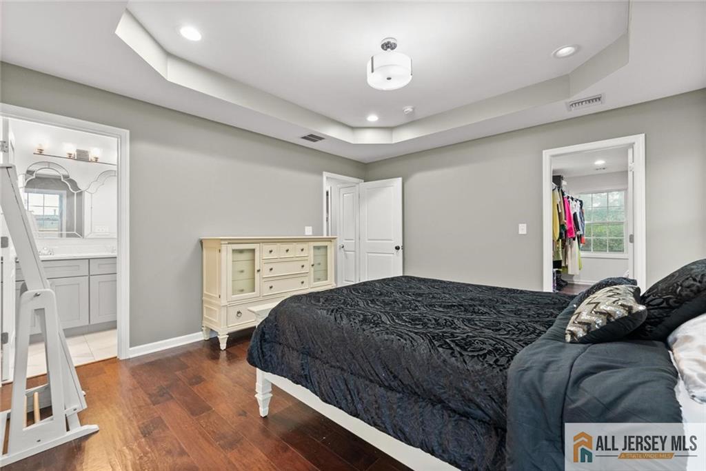 227 Temple Way Colonia, NJ 07067 - Photo 23 of 30 a bedroom with a large bed and a chandelier