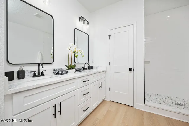 a bathroom with a double vanity sink mirror and