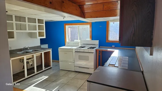 a kitchen with stainless steel appliances a stove a sink and a refrigerator