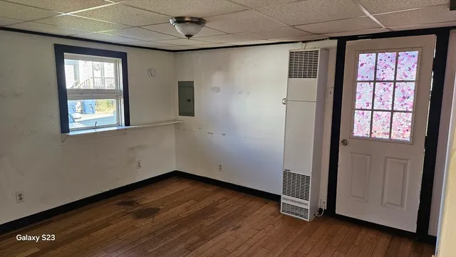 an empty room with wooden floor and windows