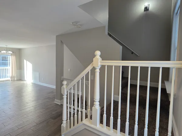 a view of staircase with railing and a rug