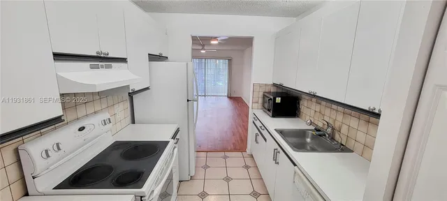 a kitchen with white cabinets and white appliances