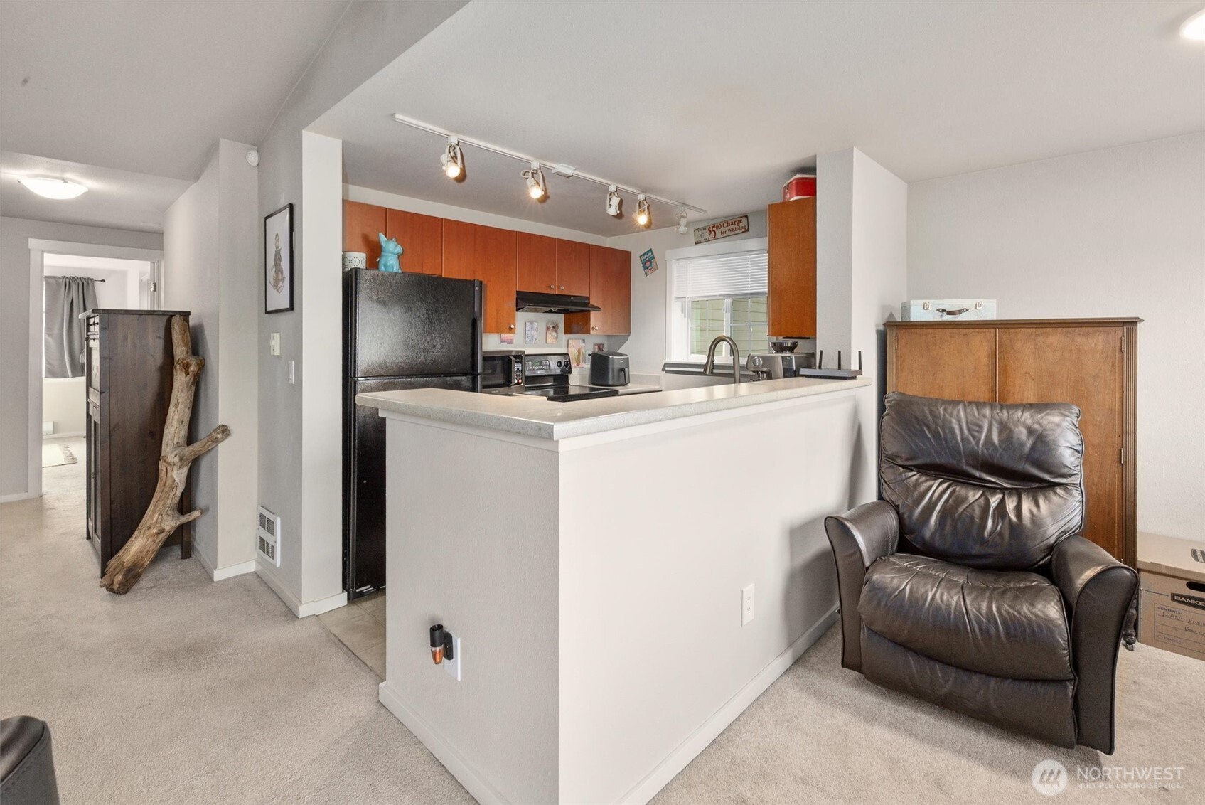 12404 East Gibson Road, Unit H301 Everett, WA 98204 - Photo 12 of 36 a living room with furniture a flat screen tv and a refrigerator