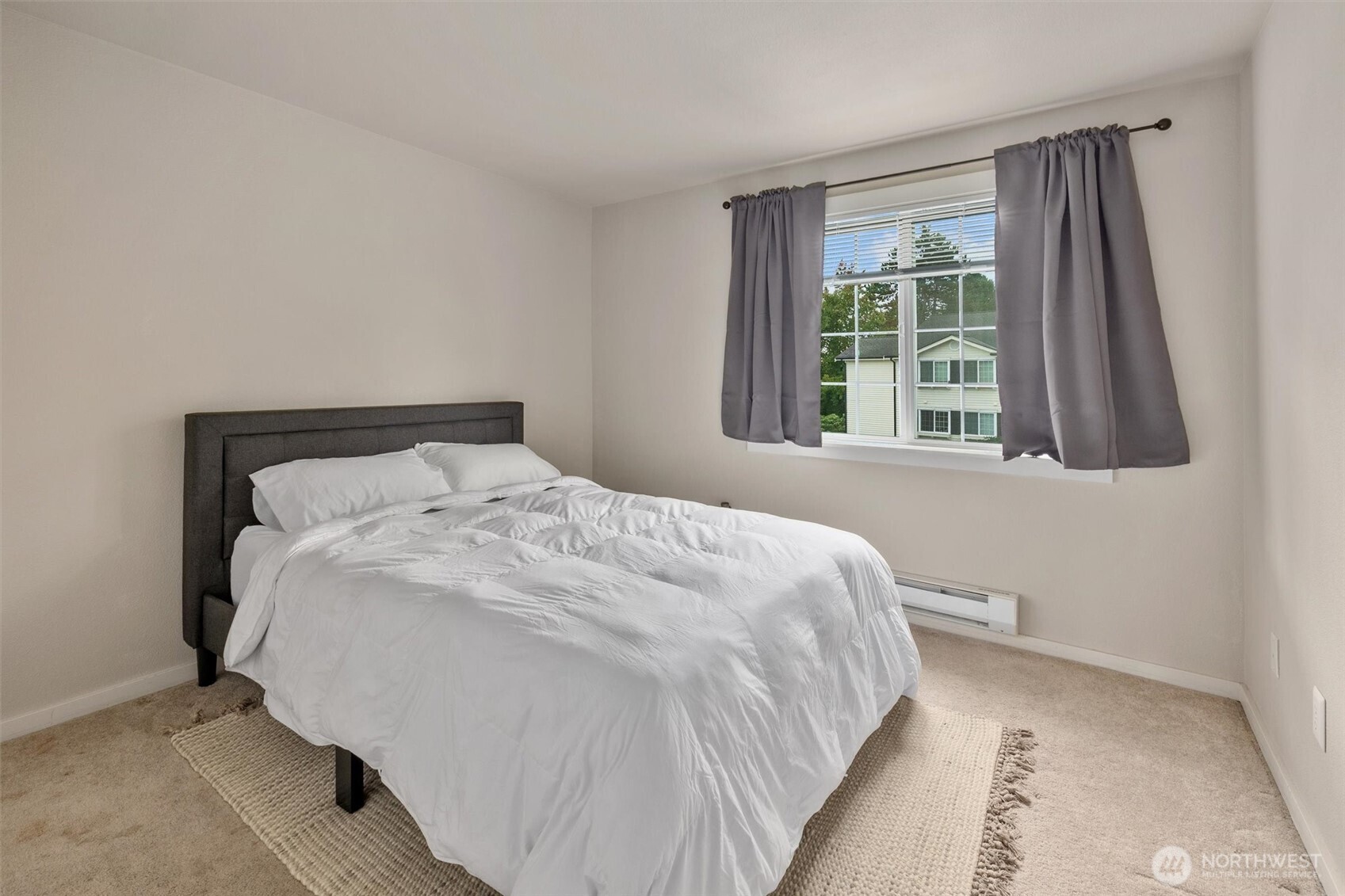 12404 East Gibson Road, Unit H301 Everett, WA 98204 - Photo 22 of 36 a large bed sitting in a bedroom next to a window