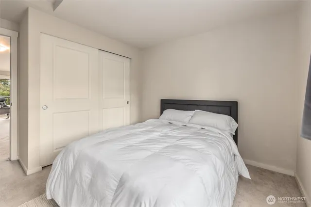 a large bed sitting in a bedroom next to a window