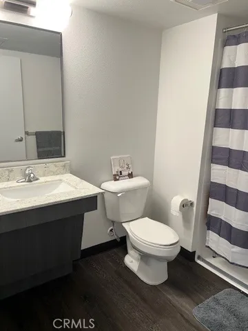a view of kitchen with refrigerator and wooden floor