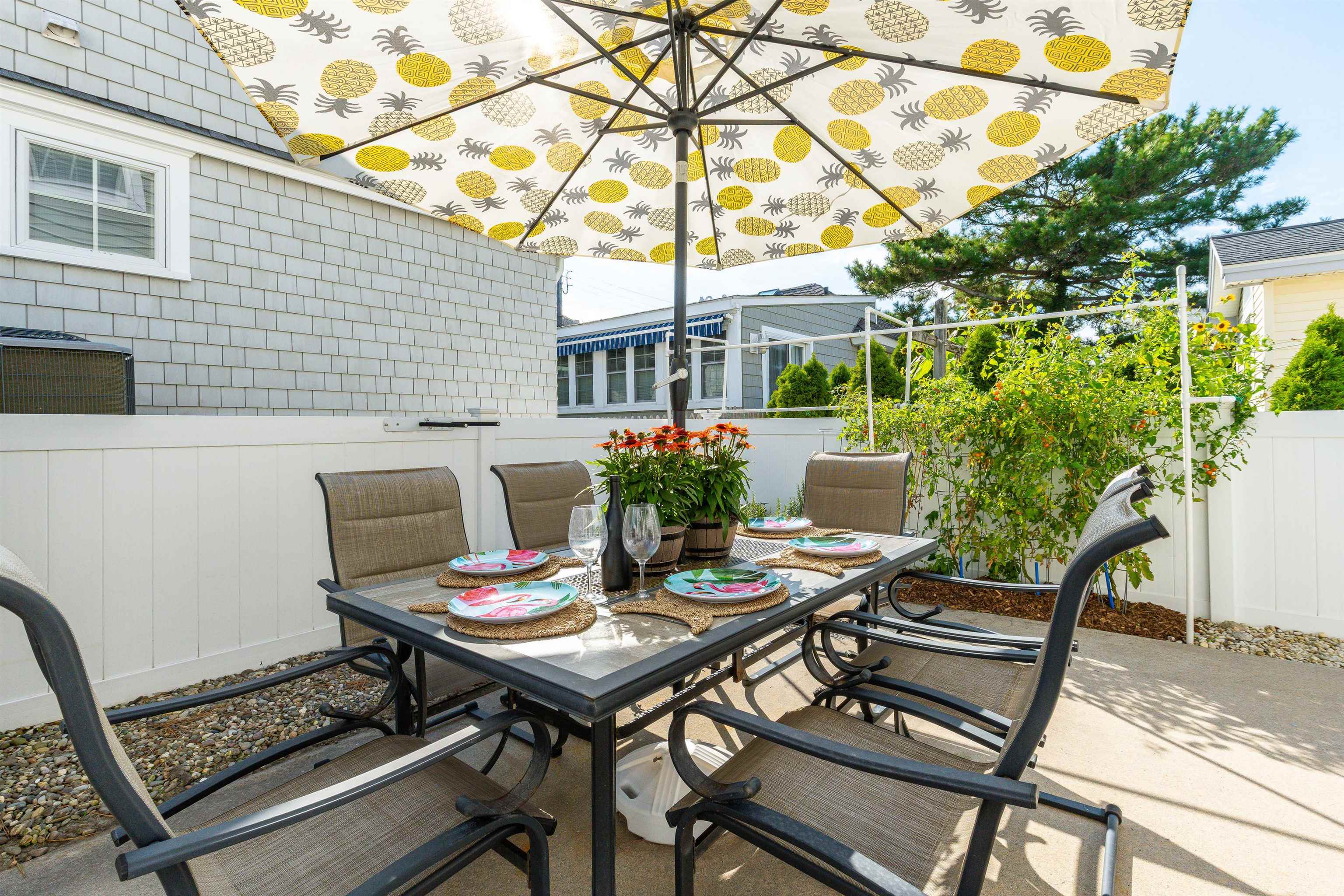 225 110th Street Stone Harbor, NJ 08247 - Photo 20 of 45 a view of a patio with a dining table and chairs