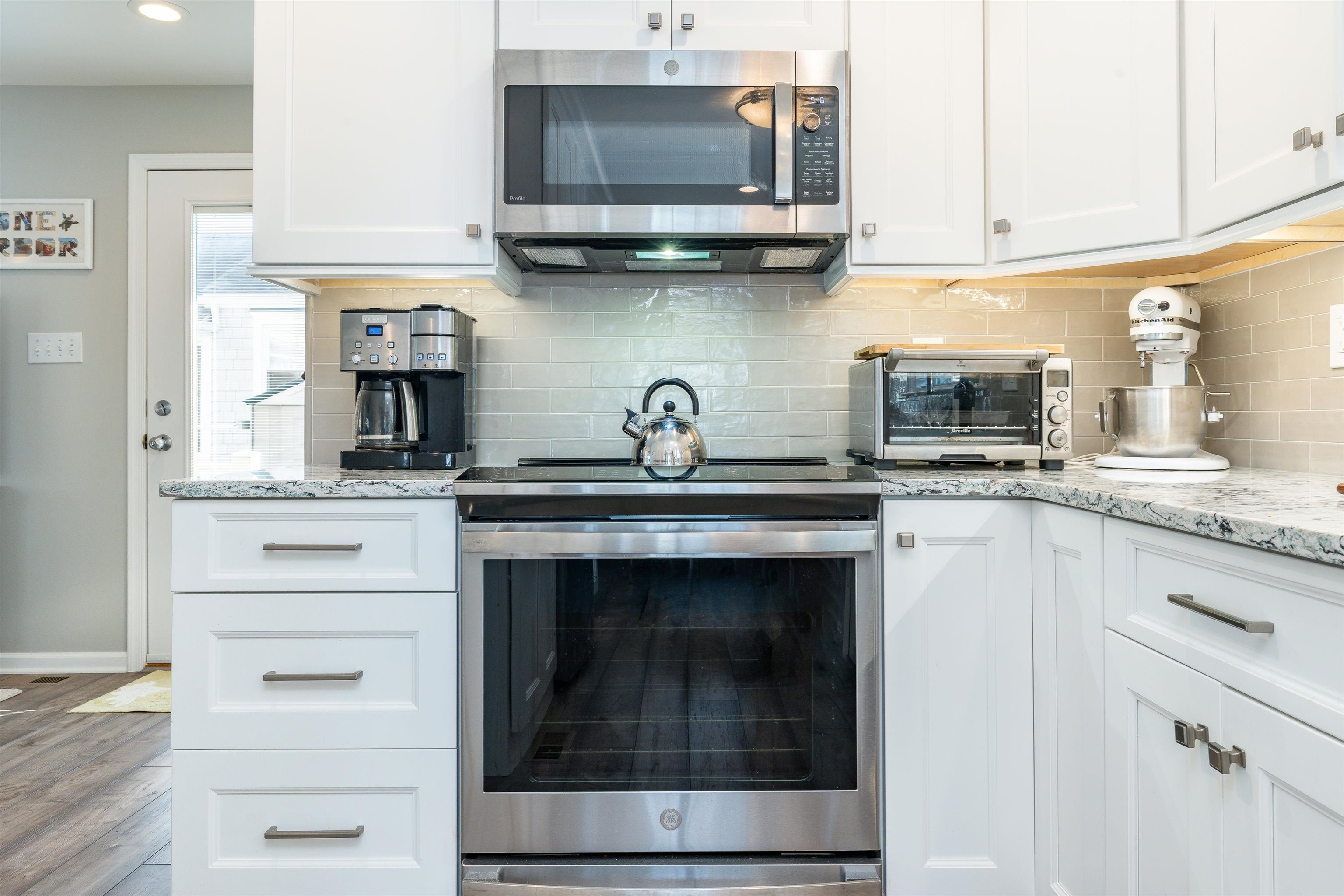 225 110th Street Stone Harbor, NJ 08247 - Photo 37 of 45 a kitchen with granite countertop a stove microwave and cabinets