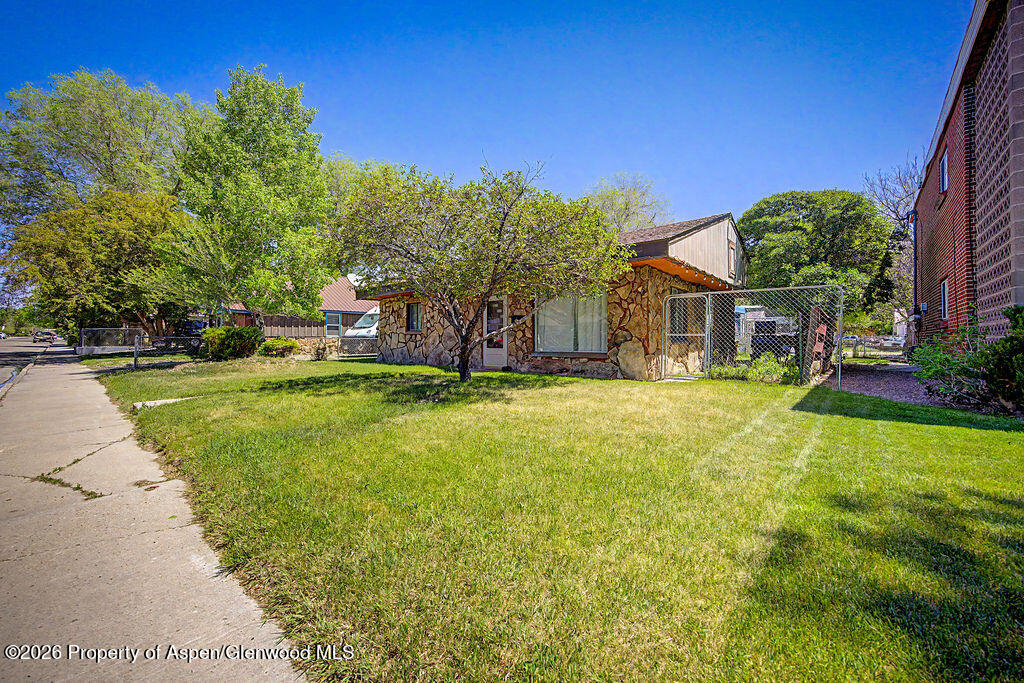 625 Russell Street Craig, CO 81625 - Photo 6 of 35 a view of a house with a big yard and large trees