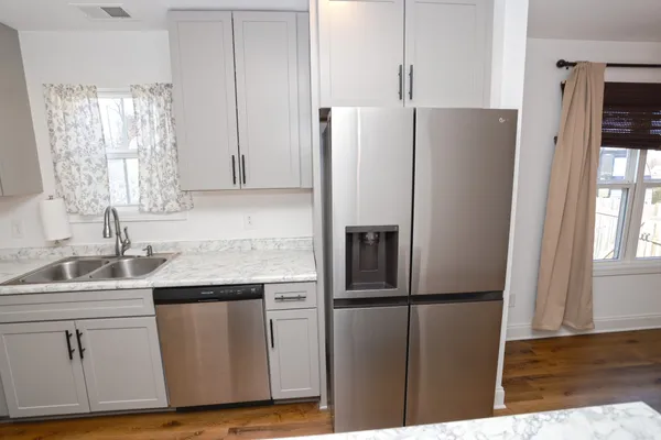 a kitchen with stainless steel appliances a refrigerator sink and microwave