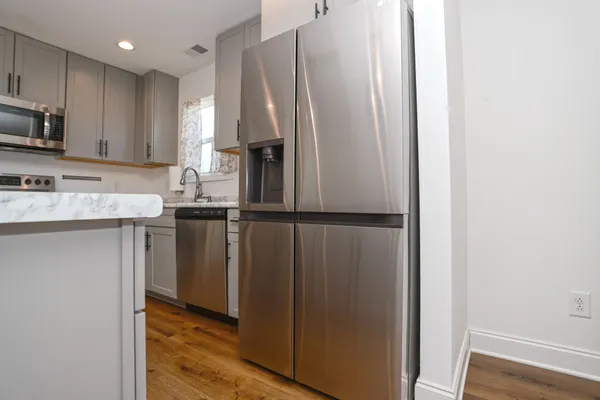 a kitchen with stainless steel appliances granite countertop a refrigerator and a sink