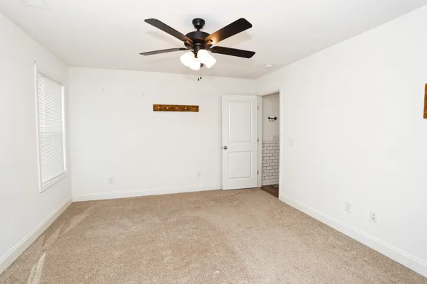 an empty room with closet and ceiling fan