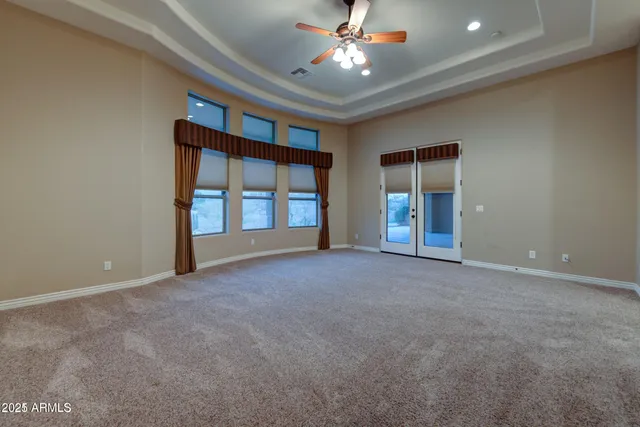 an empty room with closet and a ceiling fan