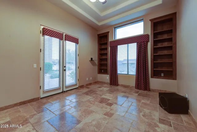 an empty room with closet and windows