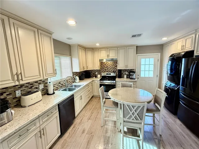 a kitchen with sink a refrigerator and chairs