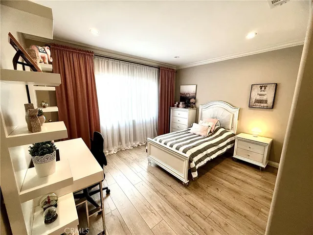 a bedroom with a bed and wooden floor