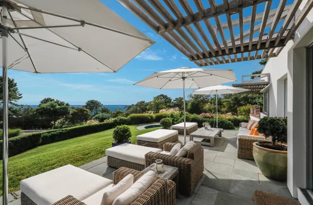 a view of a patio with couches chairs under an umbrella