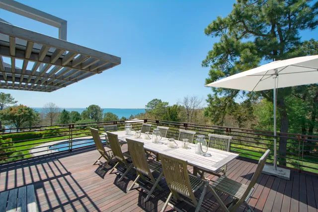 a view of a patio with wooden floor table and chairs