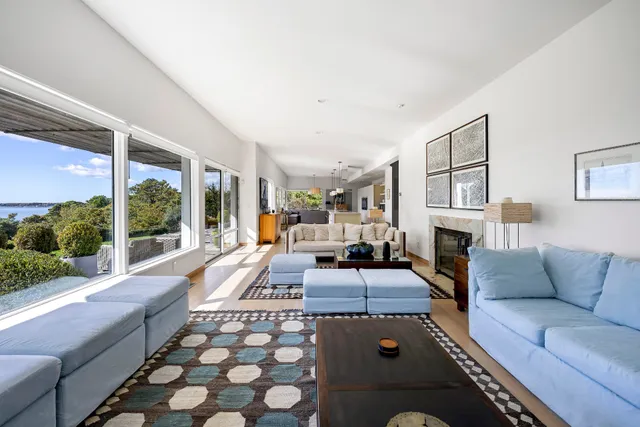 a living room with furniture fireplace and a large window