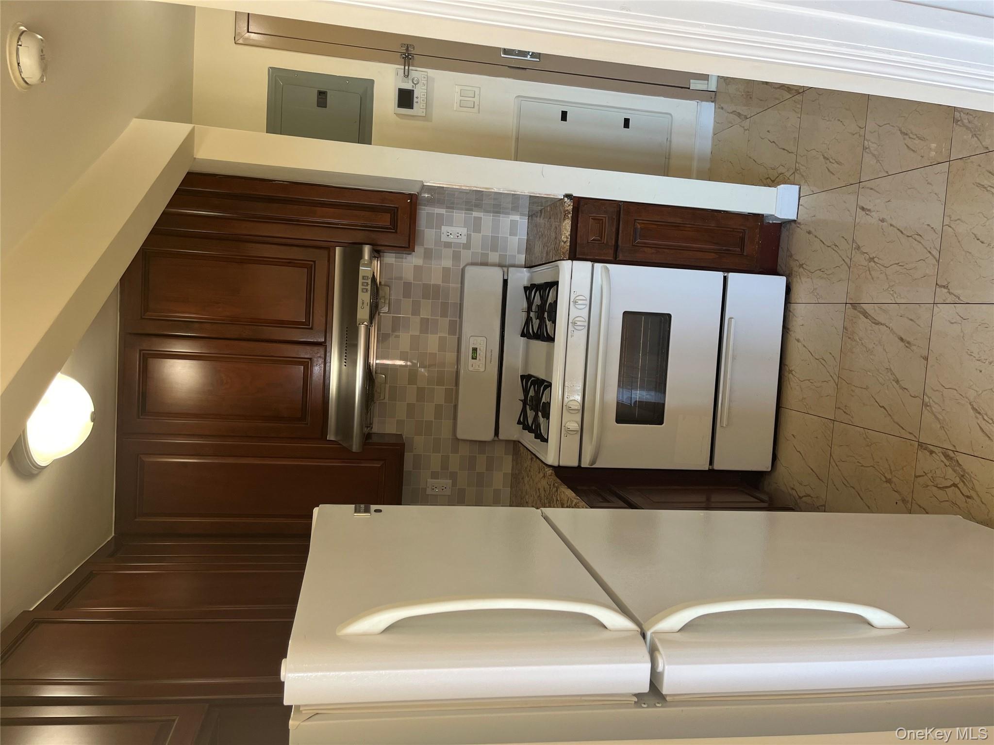 136-21 Latimer Place, Unit 3K Queens, NY 11354 - Photo 2 of 7 a kitchen with cabinets and white stainless steel appliances