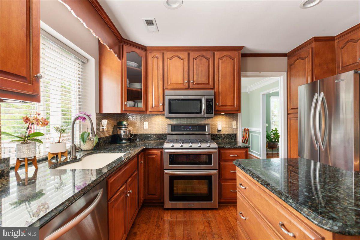 8236 Sunset Drive Manassas, VA 20110 - Photo 16 of 53 a kitchen with stainless steel appliances granite countertop a stove top oven a sink dishwasher a refrigerator and a microwave oven