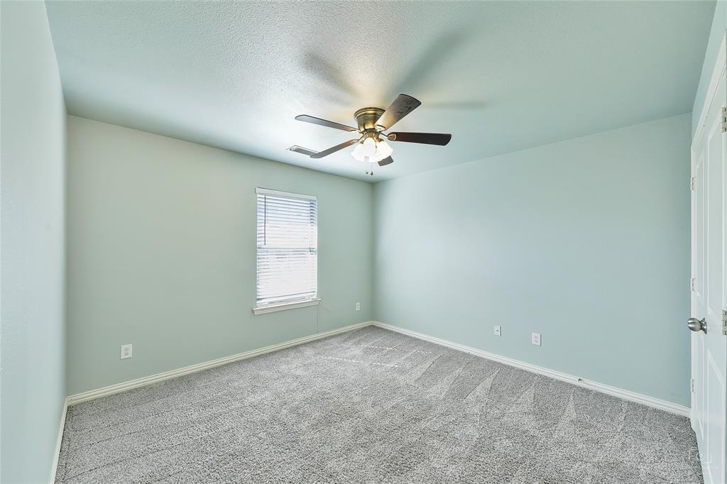 6601 Pine Hills Lane Denton, TX 76210 - Photo 16 of 23 Carpeted empty room with a ceiling fan and a textured ceiling