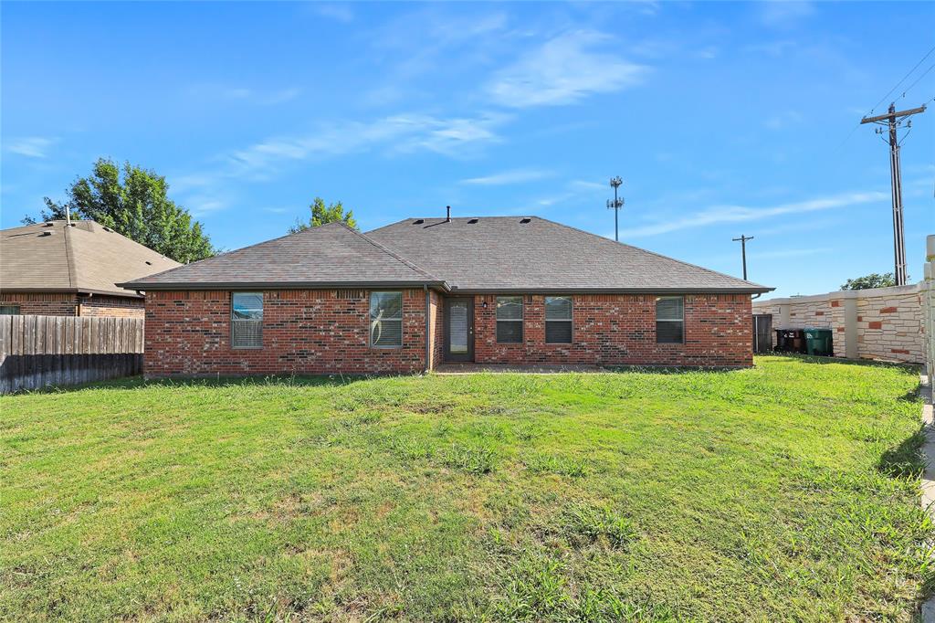 6601 Pine Hills Lane Denton, TX 76210 - Photo 22 of 23 Rear view of property with a fenced backyard, a shingled roof, brick siding, and a patio area