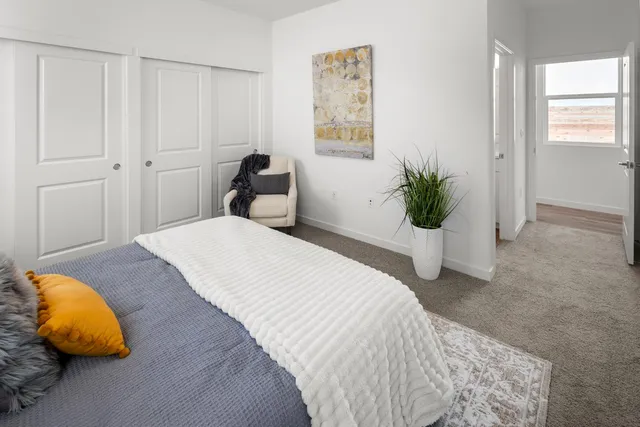 a bedroom with a bed and painting on the wall