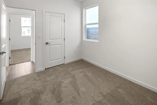 an empty room with windows and closet