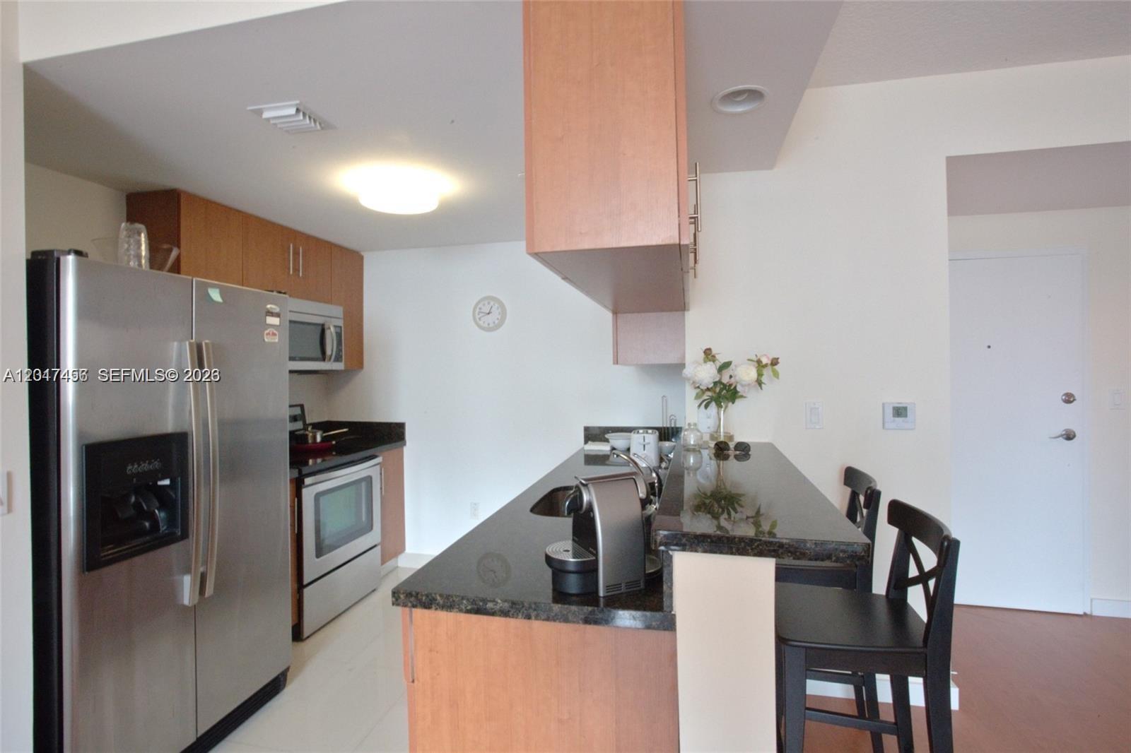 601 Northeast 23rd Street, Unit 1004 Miami, FL 33137 - Photo 6 of 17 a kitchen with stainless steel appliances granite countertop a refrigerator and a stove