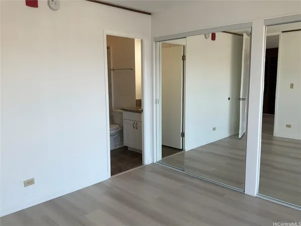 a view of a hallway with wooden floor and closet