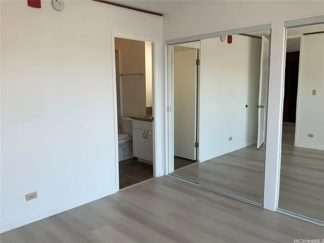 a view of a hallway with wooden floor and closet