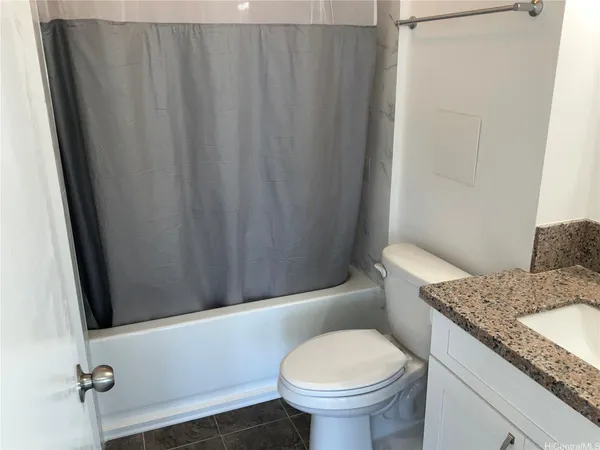 a bathroom with a granite countertop sink toilet and a mirror