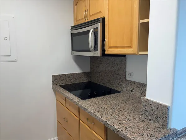 a kitchen with granite countertop white cabinets and a sink