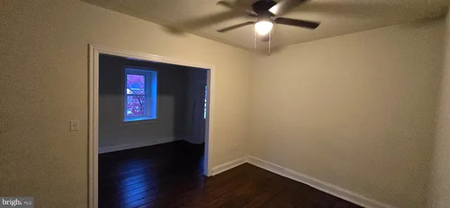 an empty room with a hardwood and ceiling fan