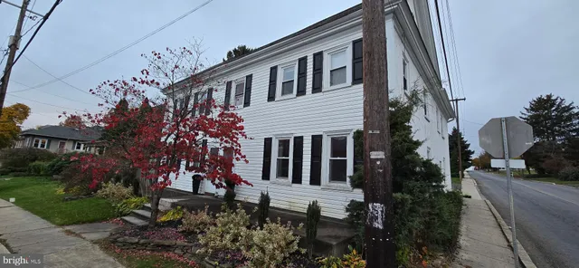 a view of a house with a yard and pathway