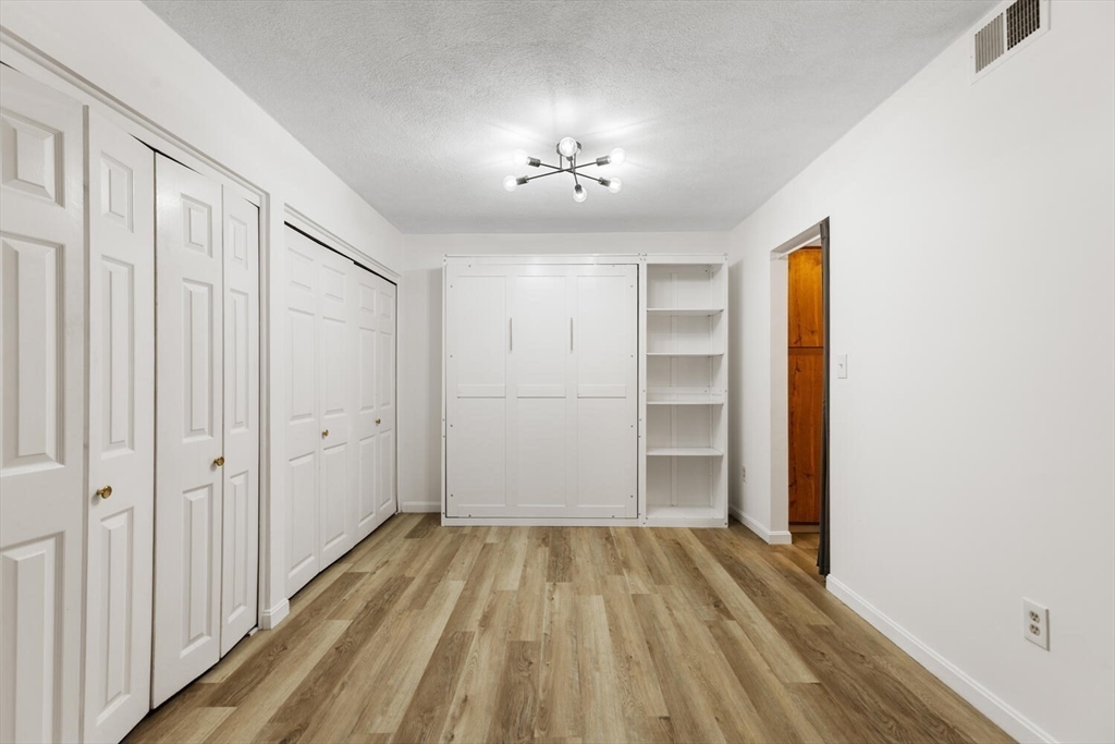 5 April, Unit 12 Lexington, MA 02421 - Photo 11 of 32 a view of a room with wooden floor closet and windows