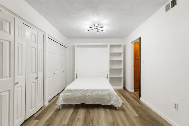 a bedroom with a bed and a chandelier