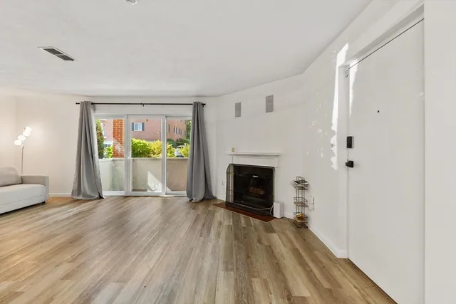 a view of an empty room with a fireplace and a window