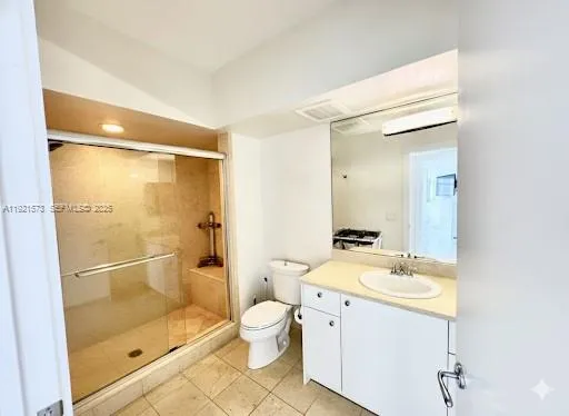 a bathroom with a granite countertop sink mirror vanity and toilet