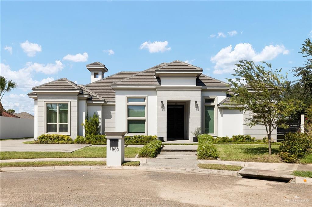 Prairie-style home with a tiled roof and stucco siding